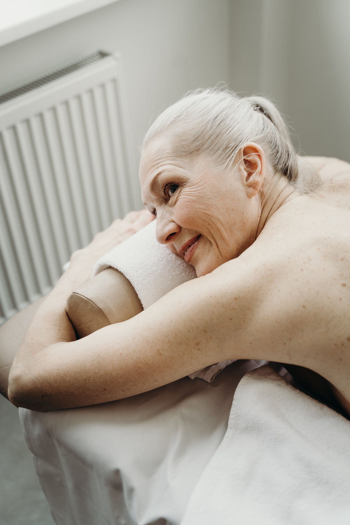 Woman resting with her head on her arms, smiling softly