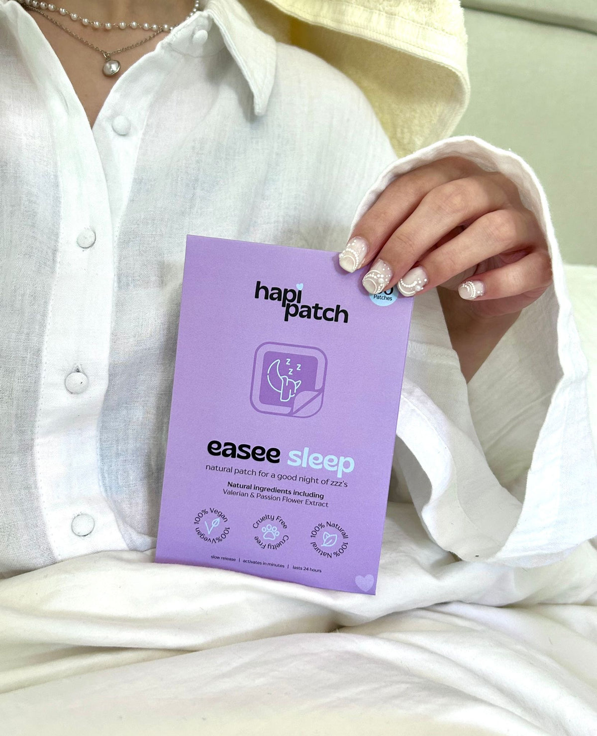 Hapi Patch Easee Sleep Patches: يدان تحملان العبوة الليلكية أمام قميص أبيض