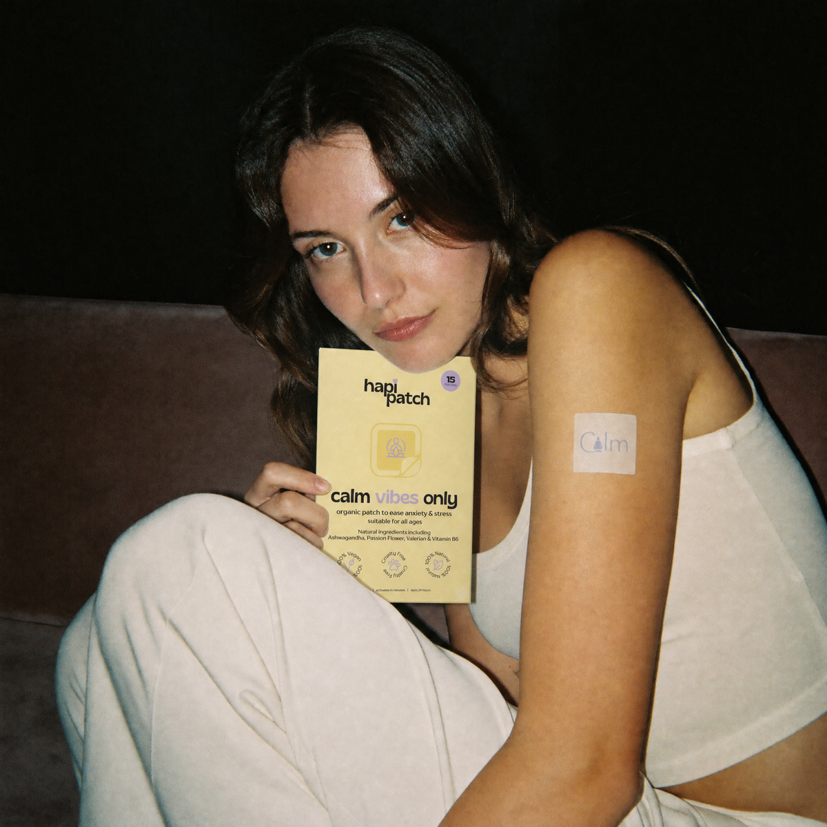 Hapi Patch Calm Vibes Only Patches: woman seated holding the pack, patch on her upper arm