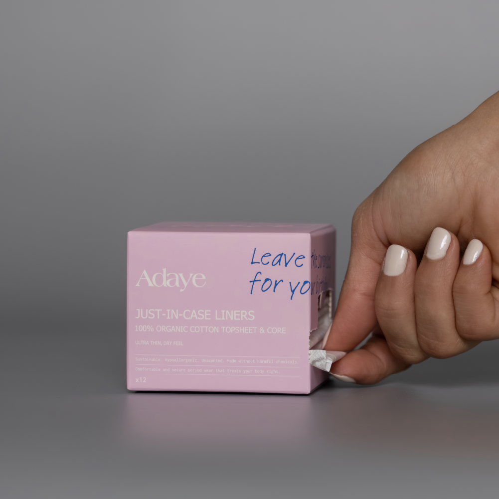 Adaye Just-in-Case Liners: hand taking a liner from the pink box on grey