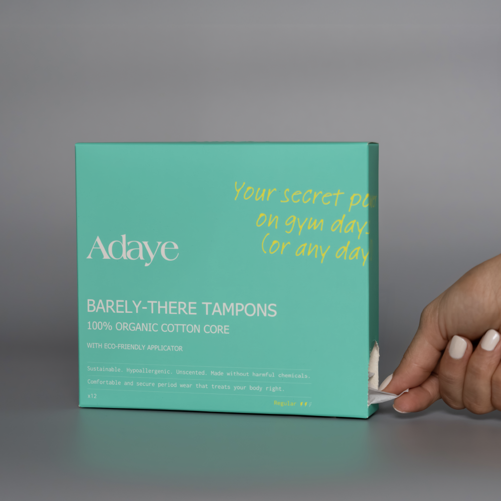 Adaye Barely-There Tampons: hand holding the green box on a grey background