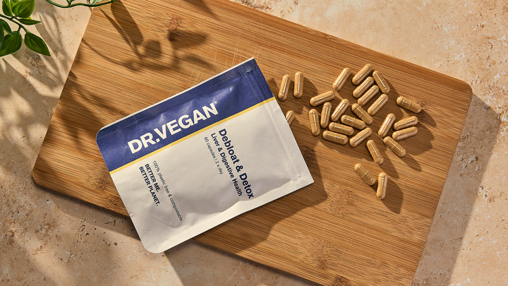 Debloat pouch and capsules on a wooden board