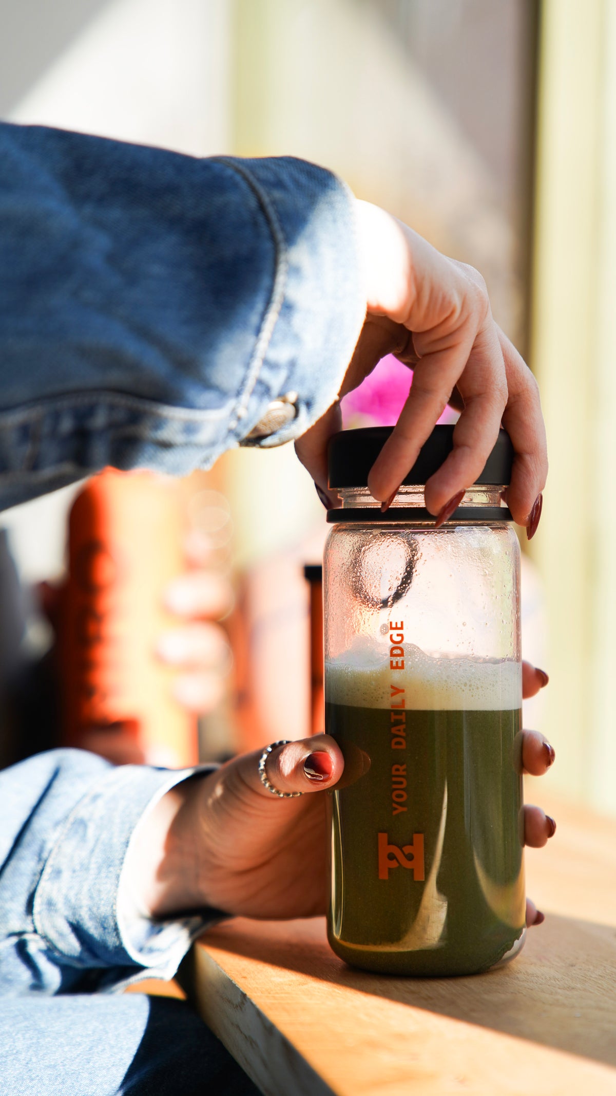 Hand mixing a green drink in the Hiro shaker