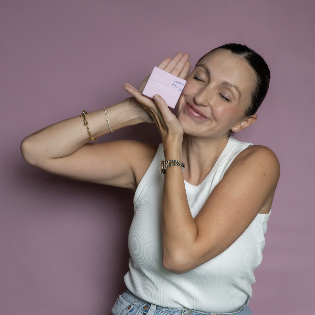 Woman smiling and holding the Adaye Just-in-Case Liners pink box